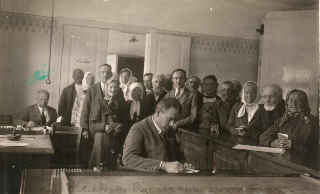 Pildot darba pienākumus.  Ilggadējais Valmieras pilsētas domes sekretārs Eduards Radziņš (1922 –1934) fiksē valmieriešu parakstus likuma izmaiņām par pensiju palielināšanu. Foto 1928.gads