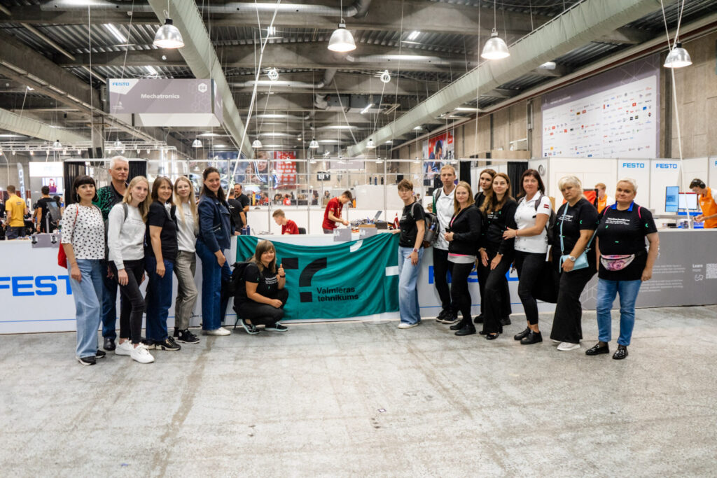 Valmieras tehnikums piedalās konkursā Euroskills, turot rokā skolas karogu.