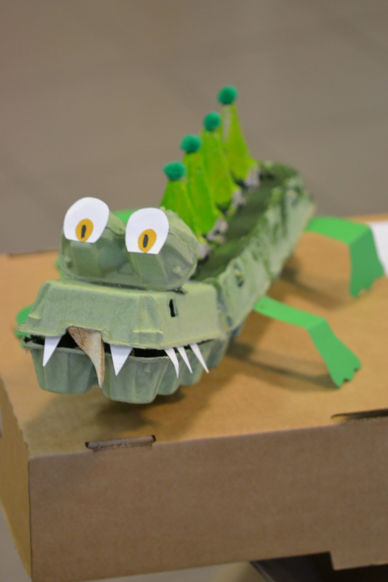 Krokodils, kas veidots no olu kastes izstādei Zaļo profesiju portreti